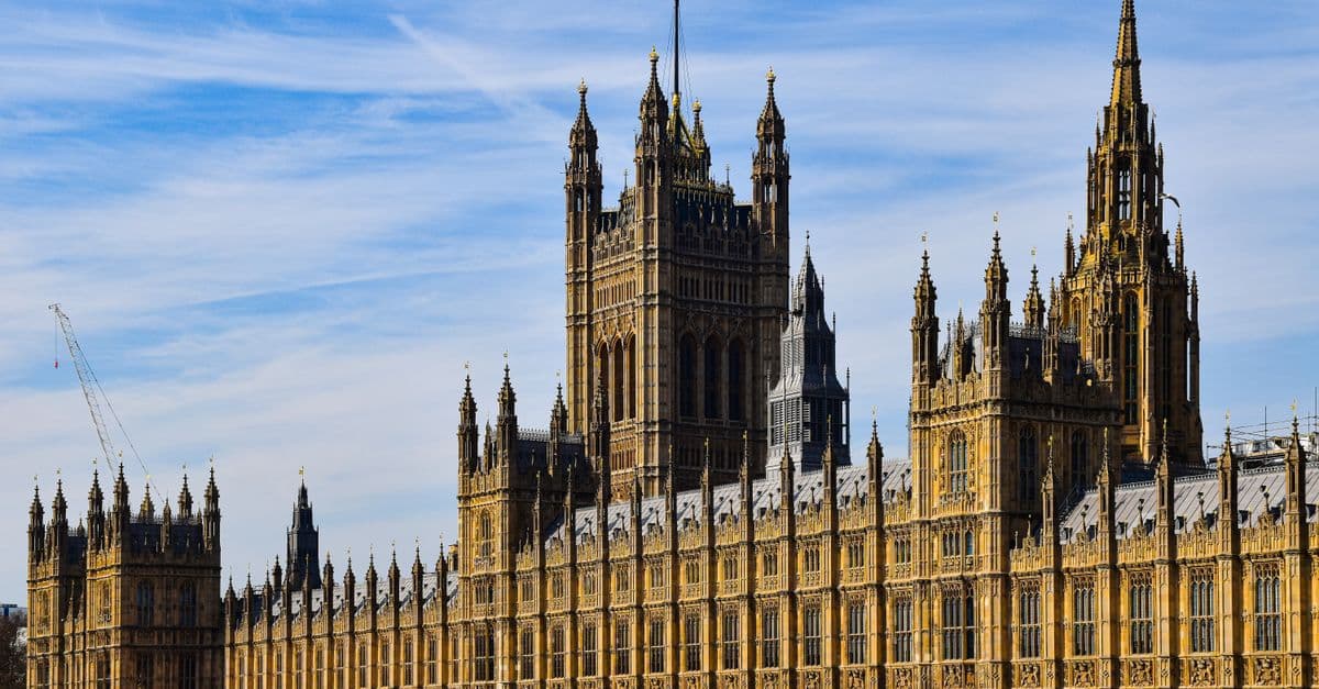 The historic Palace of Westminster in London under a clear blue sky